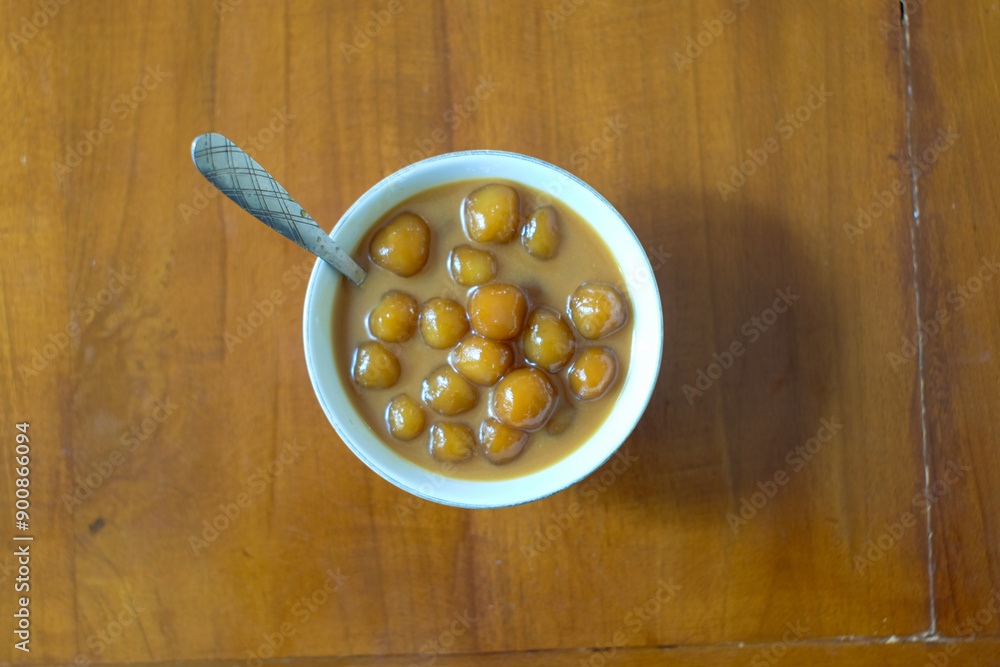 Biji salak or bubur candil is Indonesian porridge of sweet potato balls in palm sugar syrup and coconut milk sauce on the table . Very popular during Ramadan. Biji salak or bubur candil is Indonesian porridge of sweet potato balls in palm sugar syrup and coconut milk sauce on the table . Very popular during Ramadan.