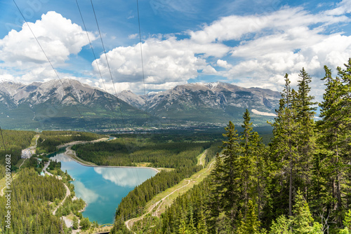 Views looking over Canmore in northern Canada during summer time from the Grassi Lakes trail with towering mountains surrounding the stunning, wilderness area. 