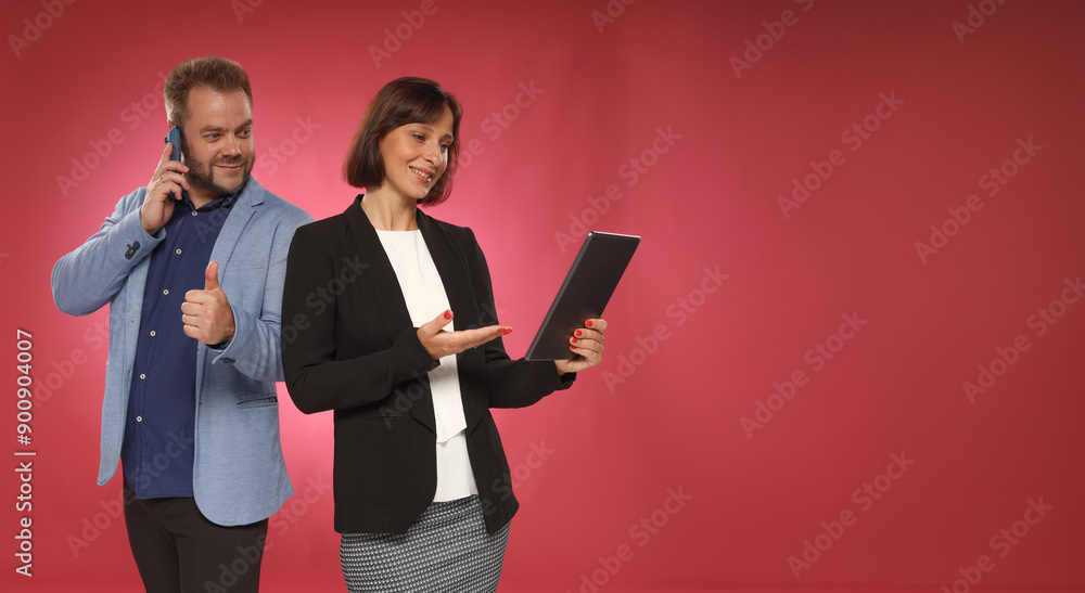 A couple of business people are looking at the tablet screen cheerfully A couple of business people are looking at the tablet screen cheerfully