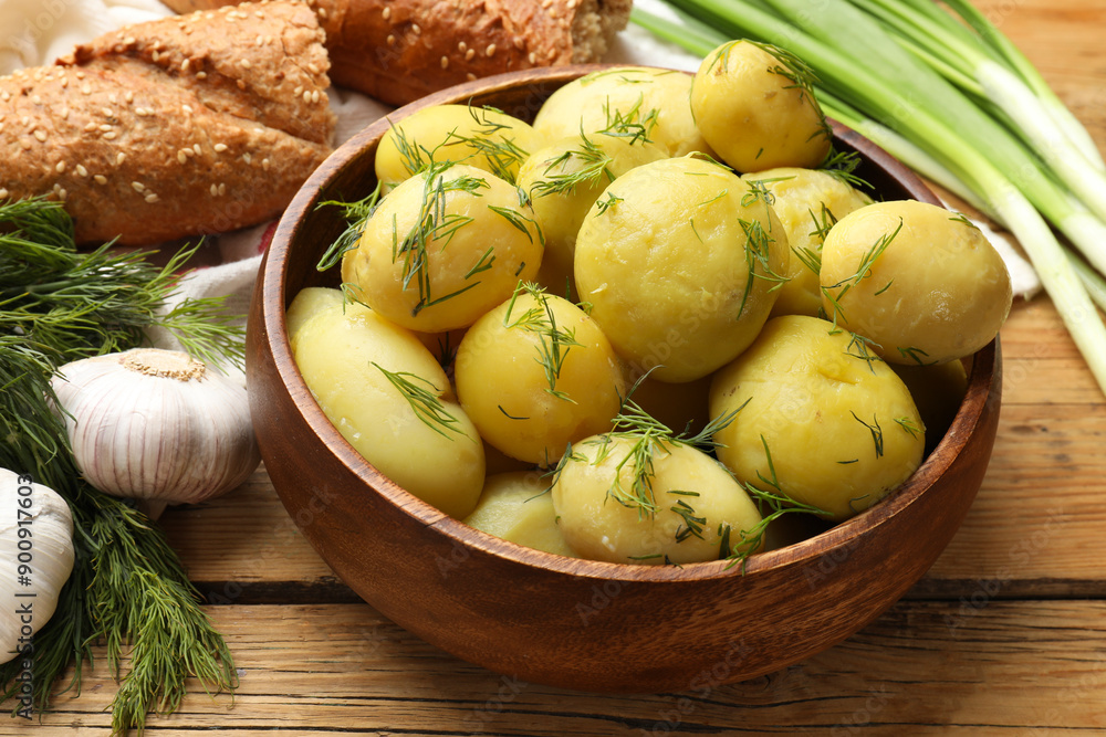 Tasty young boiled potatoes in bowl served on wooden table Tasty young boiled potatoes in bowl served on wooden table