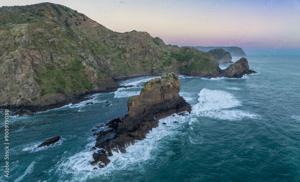 Rocky coastline, ocean waves and rocky island at Anawhata at sunset, Piha, Auckland, New Zealand. Rocky coastline, ocean waves and rocky island at Anawhata at sunset, Piha, Auckland, New Zealand.