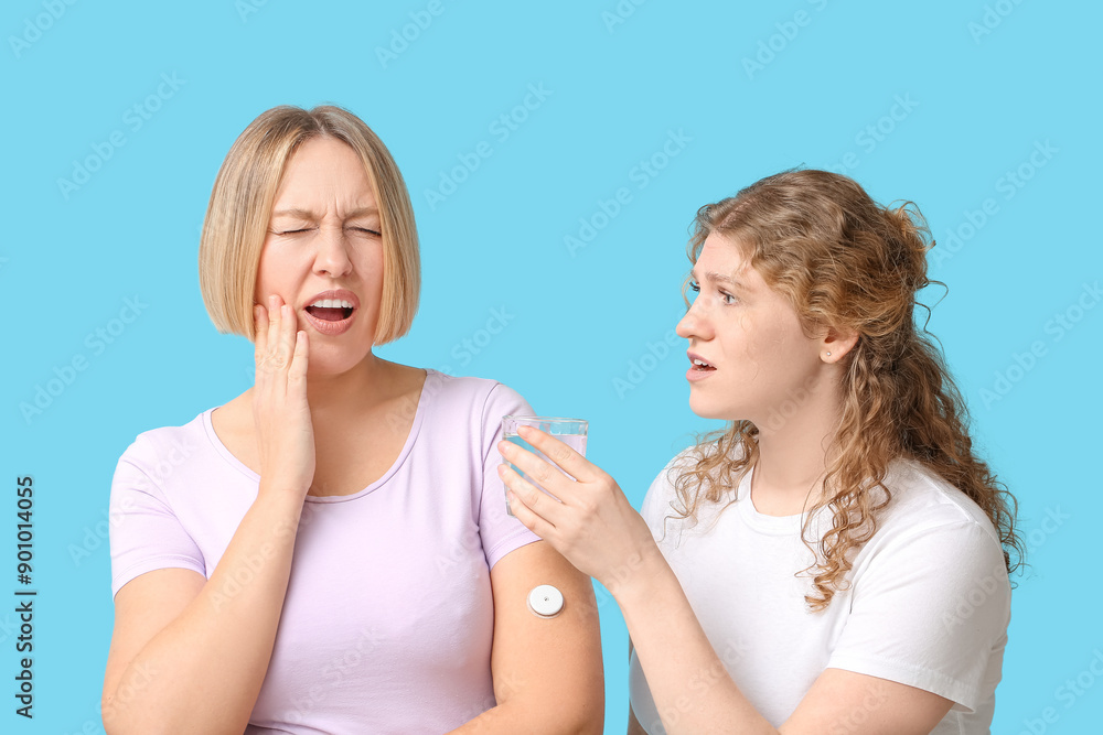 Beautiful women suffering from toothache on blue background Beautiful women suffering from toothache on blue background