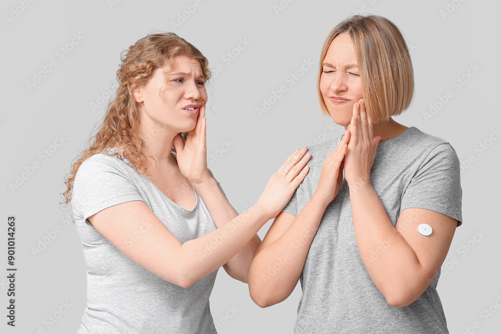 Beautiful women suffering from toothache on grey background Beautiful women suffering from toothache on grey background