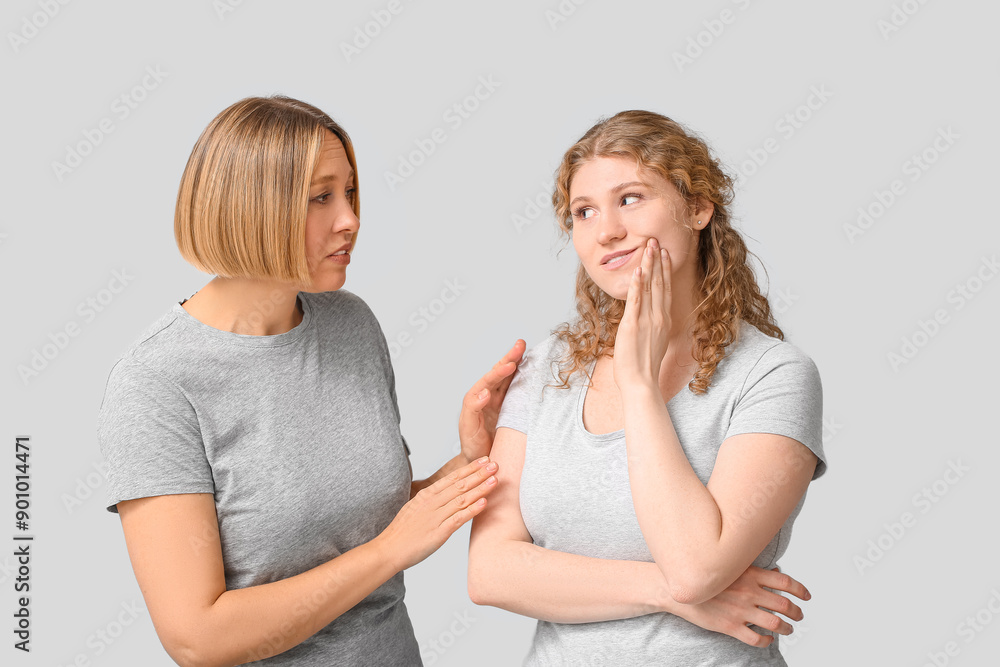Beautiful women suffering from toothache on grey background Beautiful women suffering from toothache on grey background