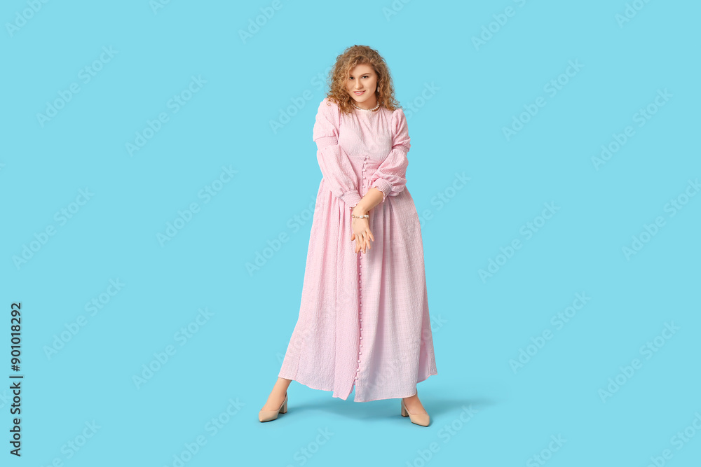 Beautiful young woman in stylish pink dress on blue background Beautiful young woman in stylish pink dress on blue background