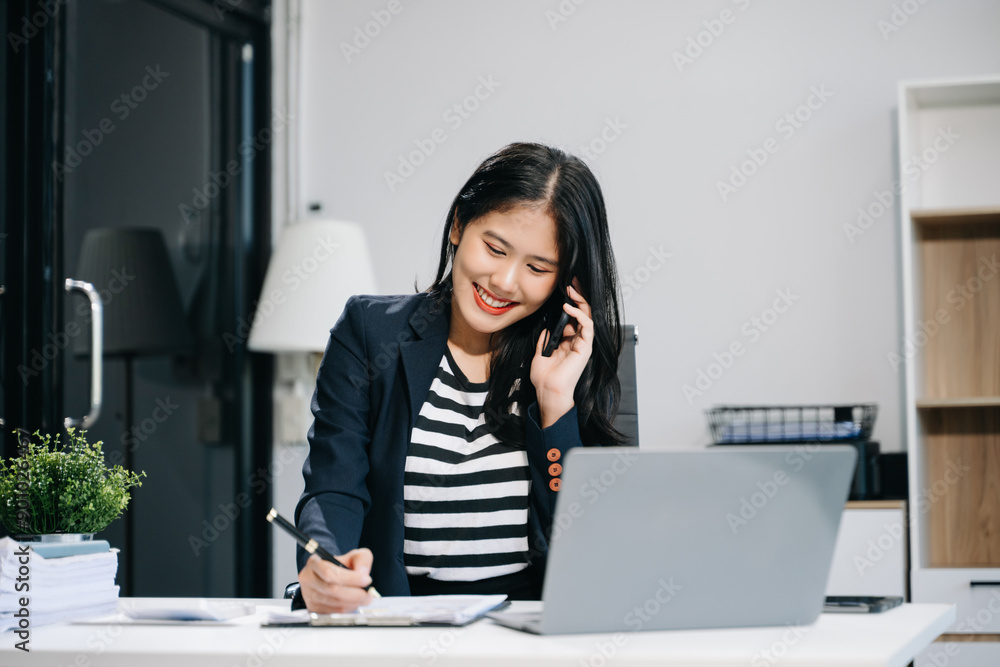 Asian businesswoman working in the office with working notepad, tablet and laptop documents Asian businesswoman working in the office with working notepad, tablet and laptop documents