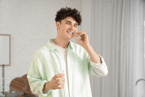 Young man taking fish oil a...
