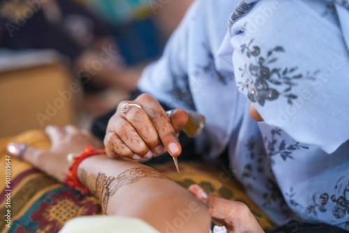 Mumbai, India 23rd July 2024: Close-up shots of an Indian bride getting henna also known as Mehendi or mehndi done. Henna pattern. Traditional Rasam or rivaz of done with henna mehandi photo