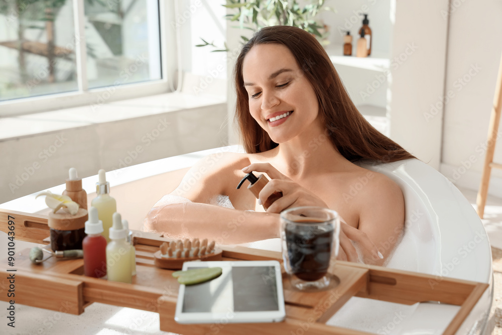 Beautiful young happy woman applying cosmetic products and taking bath with soap foam at home Beautiful young happy woman applying cosmetic products and taking bath with soap foam at home