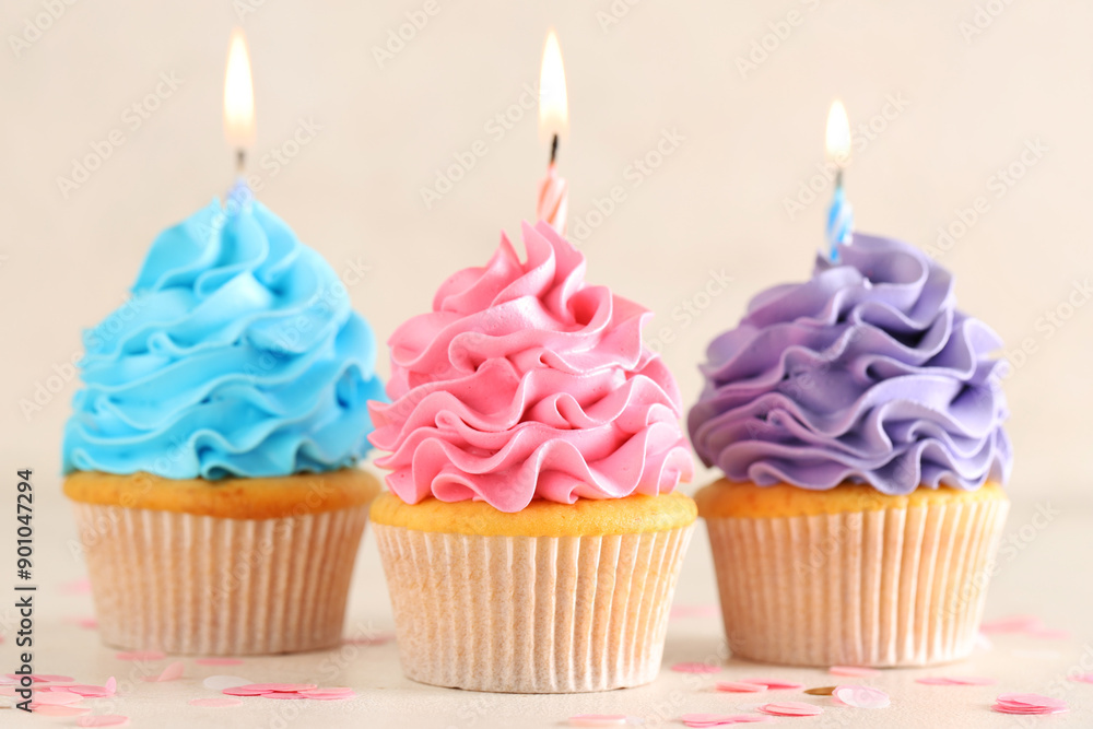 Different sweet Birthday cupcakes with burning candles on white background Different sweet Birthday cupcakes with burning candles on white background