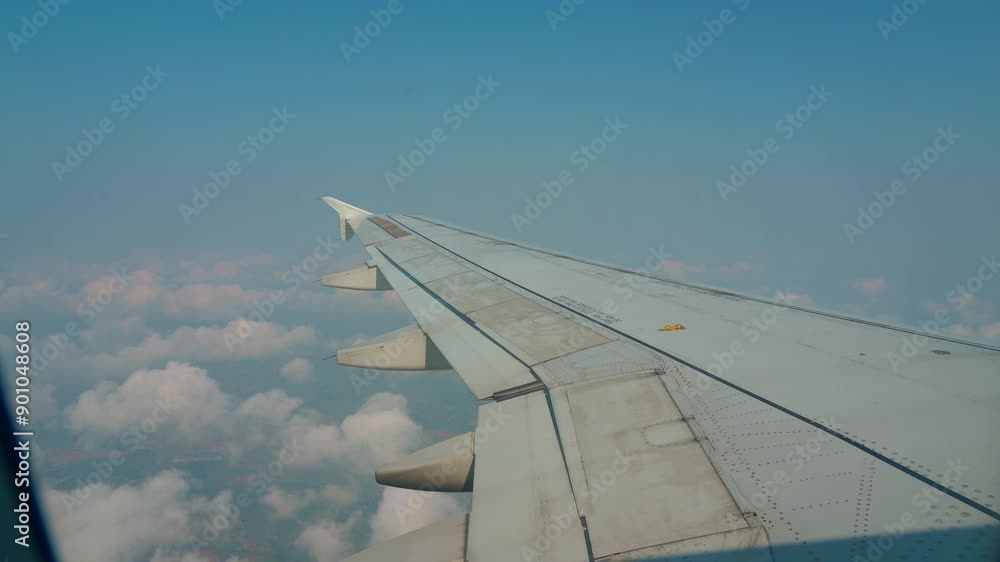 Window seat view of plane flying high above the clouds blue skies travel flight. Passenger view from airplane window flying above the sky. Travel concept Window seat view of plane flying high above the clouds blue skies travel flight. Passenger view from airplane window flying above the sky. Travel concept