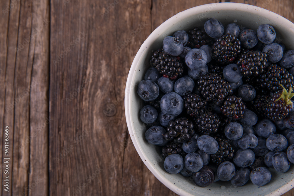 Ripe black blackberries and blue blueberries on a wooden table Ripe black blackberries and blue blueberries on a wooden table