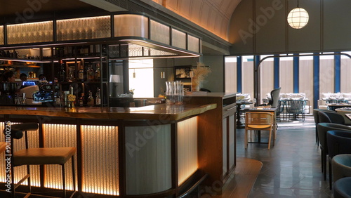 Modern interior of cozy bar with stylish furniture and warm lighting, ideal for relaxing evening or social gatherings in upscale environment. Hospitality and Leisure.