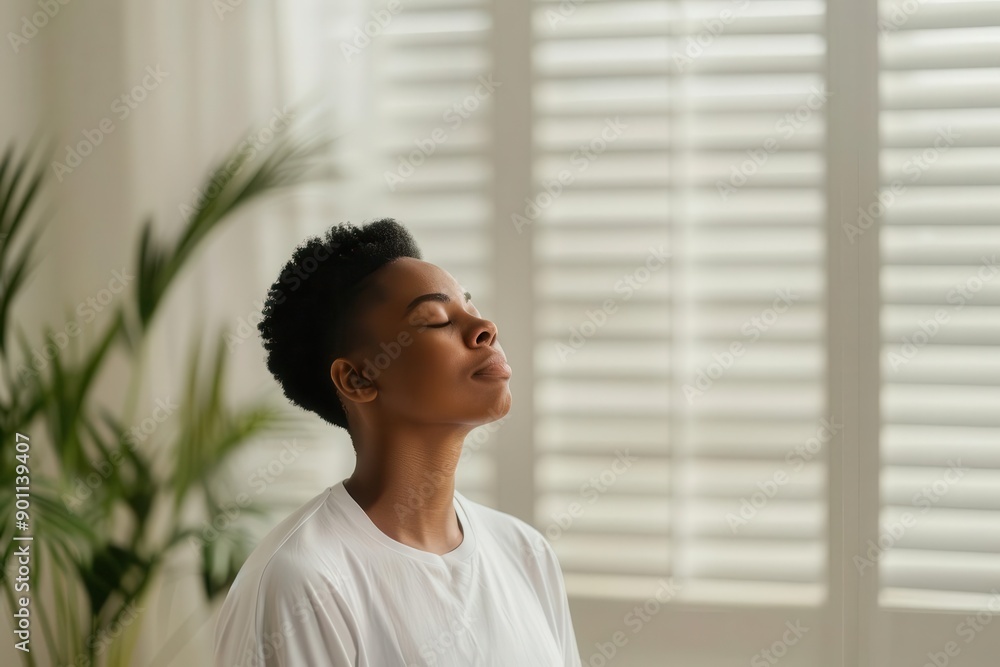 Black woman practicing deep breathing exercises in a quiet room, immediate stress relief method Black woman practicing deep breathing exercises in a quiet room, immediate stress relief method