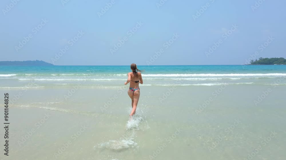 Happy Caucasian woman raises her hands and runs into the turquoise sea on paradise beach - Concepts of freedom, tropical vacation, travel. Happy Caucasian woman raises her hands and runs into the turquoise sea on paradise beach - Concepts of freedom, tropical vacation, travel.