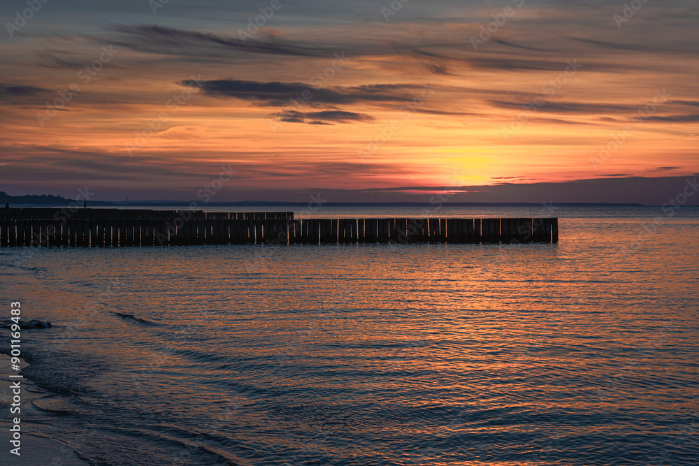 View of sand beach with wooden breakwaters on the Baltic Sea coast on sunset in Zelenogradsk. Russia