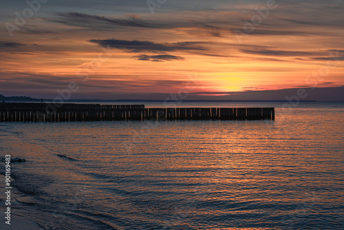 View of sand beach with wooden breakwaters on the Baltic Sea coast on sunset in Zelenogradsk. Russia