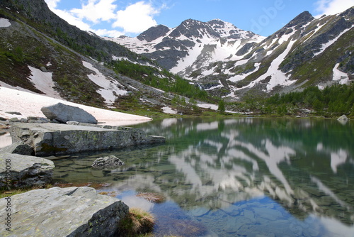 Reflections on The Lago Arpy (Arpy lake) located in the Italian Alps, La Thuile, Aosta Valley, surrounded by mountains and glaciers