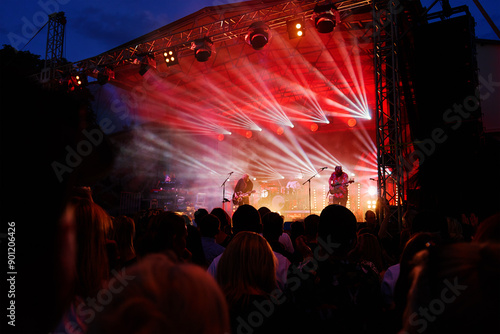 Φωτογραφία Silhouettes of crowd at concert in front of stage with bright spotlights