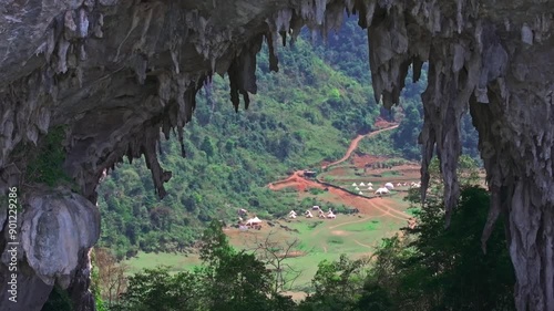 This stunning footage captures a breathtaking view from Angel Eye Mountain in Cao Bang, North Vietnam. The natural rock formation perfectly frames a scenic campsite nestled in a lush, green valley. 