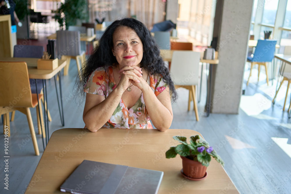 57-year-old woman works on a laptop in a modern office workspace 57-year-old woman works on a laptop in a modern office workspace