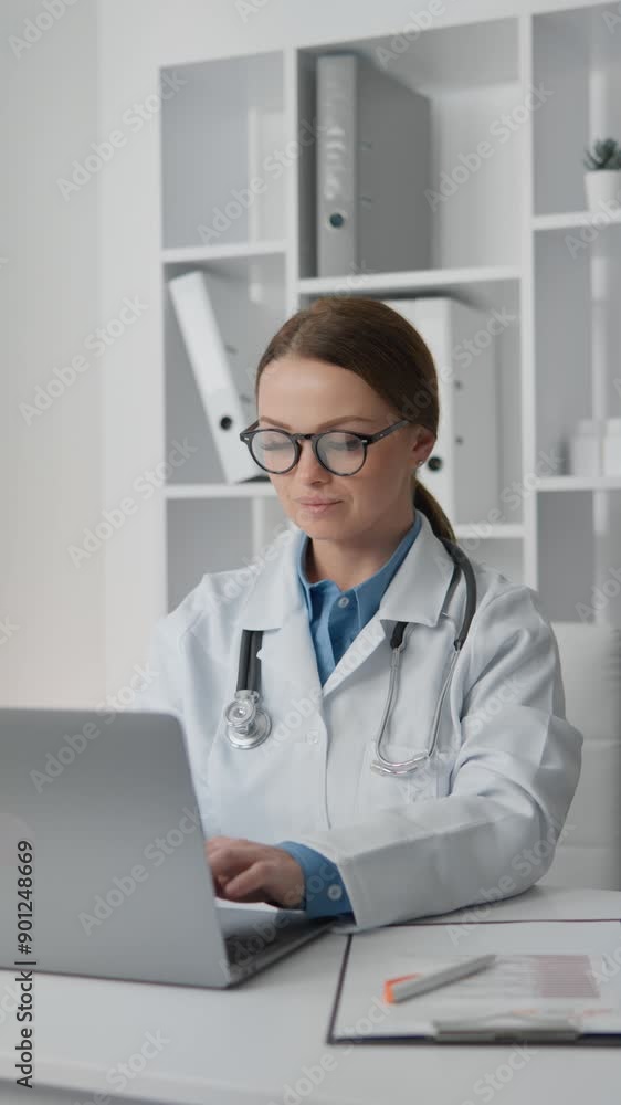 In a modern office, a female physician is working on her laptop, indicating a healthcare environment with professionals such as doctors in a medical setting. The scene is focused on a doctor at work In a modern office, a female physician is working on her laptop, indicating a healthcare environment with professionals such as doctors in a medical setting. The scene is focused on a doctor at work