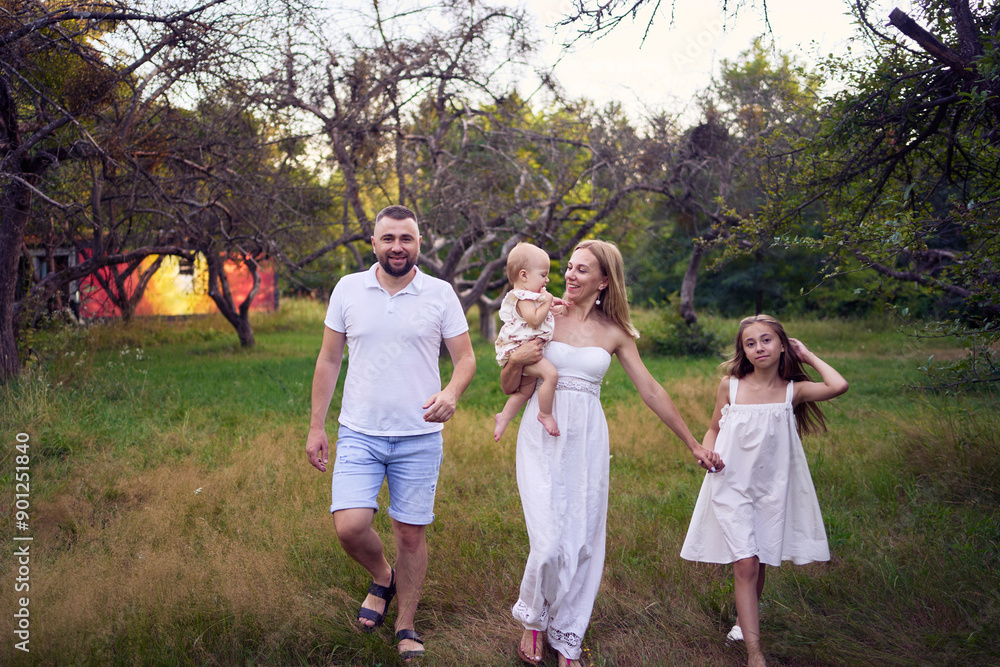 Fototapeta premium family of four on a walk in the park