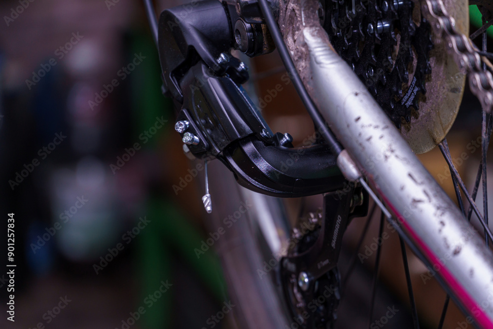 Obraz premium Mountain bike repair and maintenance. The rear derailleur is a close-up on a black background.