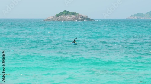 Kayaker paddling in turquoise waters by redang island, malaysia photo