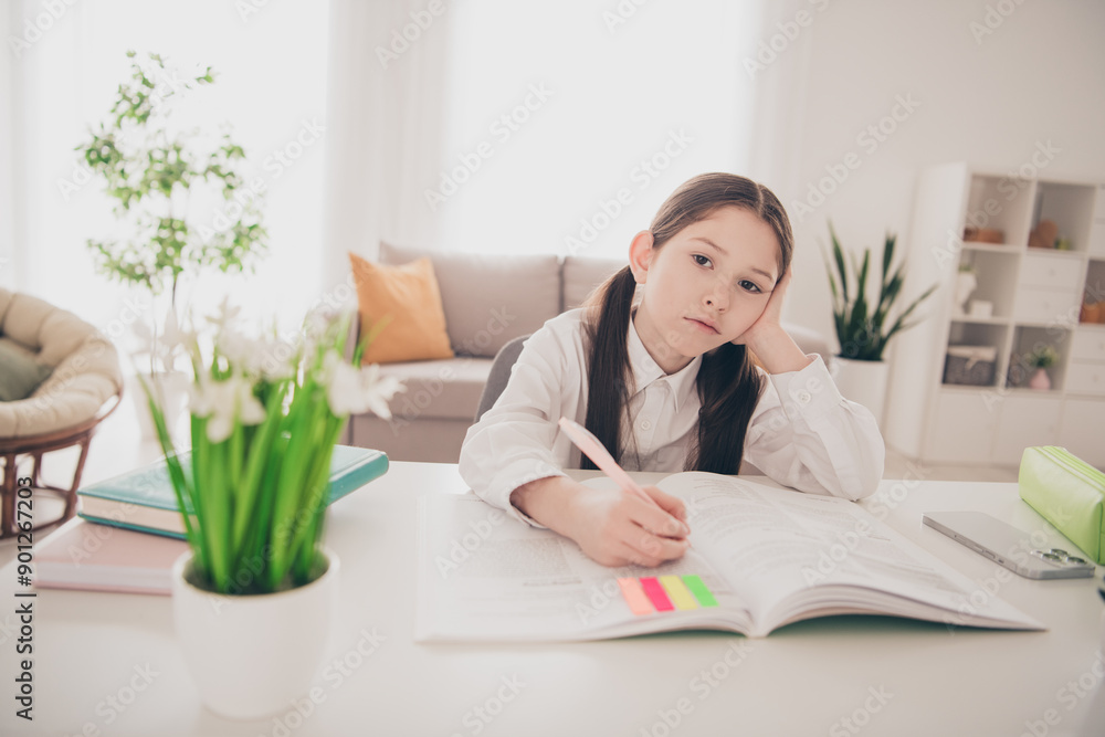 Photo portrait of cute adorable girl unhappy tired write textbook homework remote lesson education from home indoors Photo portrait of cute adorable girl unhappy tired write textbook homework remote lesson education from home indoors