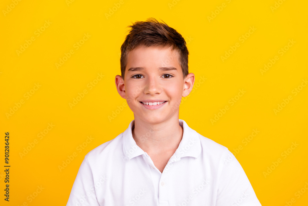Photo of funny charming boy wear white t-shirt smiling emtpy space isolated yellow color background Photo of funny charming boy wear white t-shirt smiling emtpy space isolated yellow color background