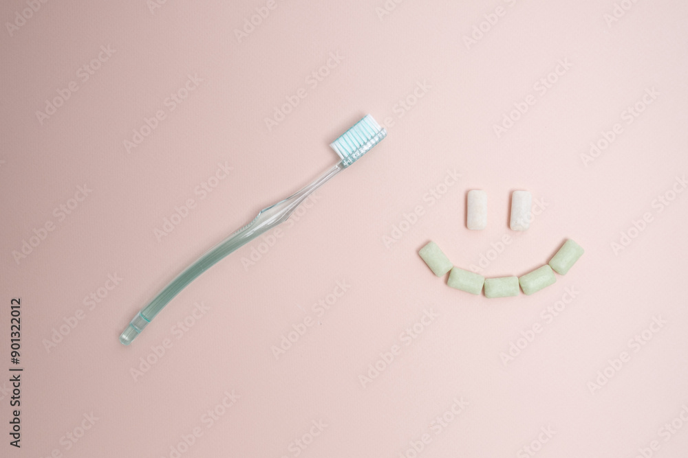 Toothbrush and chewing gum lie on a colored background. Time to brush your teeth. Top view, flat lay. Dental health concept Toothbrush and chewing gum lie on a colored background. Time to brush your teeth. Top view, flat lay. Dental health concept