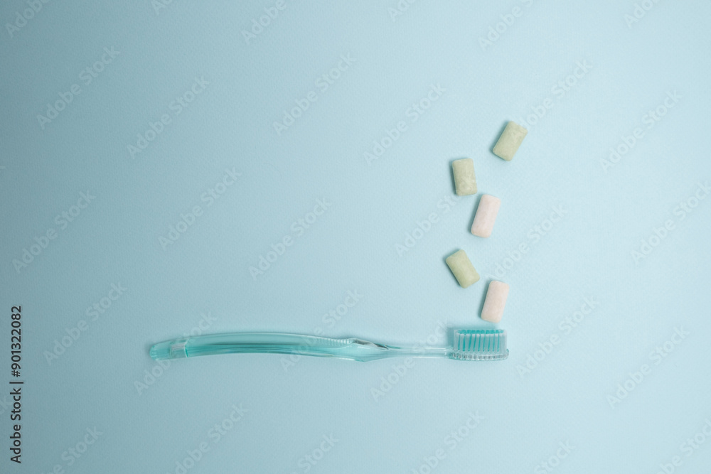 Toothbrush and chewing gum lie on a colored background. Time to brush your teeth. Top view, flat lay. Dental health concept Toothbrush and chewing gum lie on a colored background. Time to brush your teeth. Top view, flat lay. Dental health concept