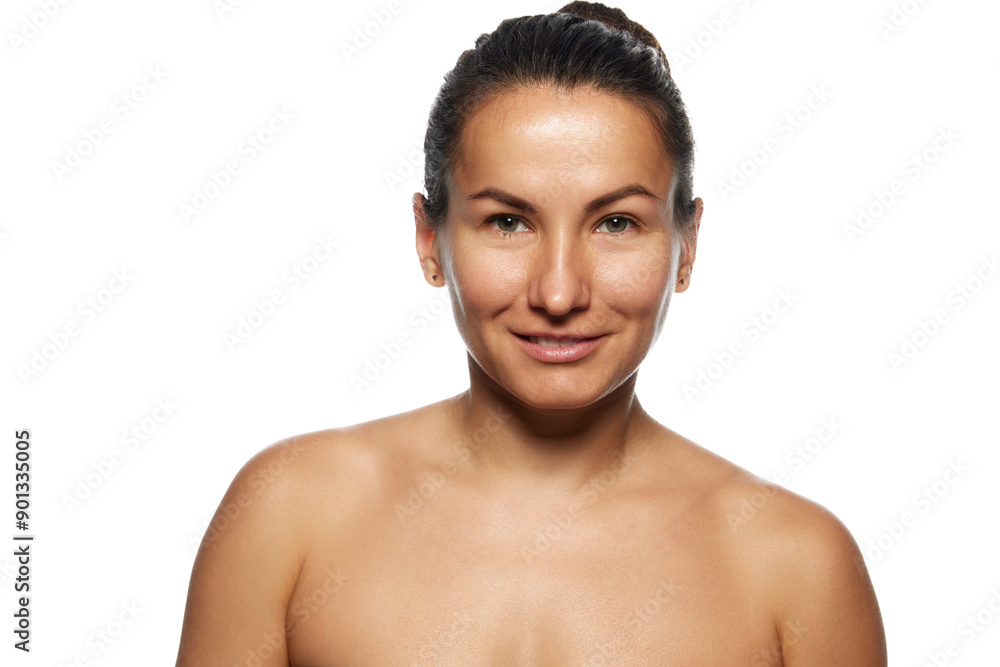 Portrait of beautiful woman with bare shoulders looking with smile at camera against white studio background. Model without make-up. Concept of facial care, lifting, spa procedures, surgery. Portrait of beautiful woman with bare shoulders looking with smile at camera against white studio background. Model without make-up. Concept of facial care, lifting, spa procedures, surgery.