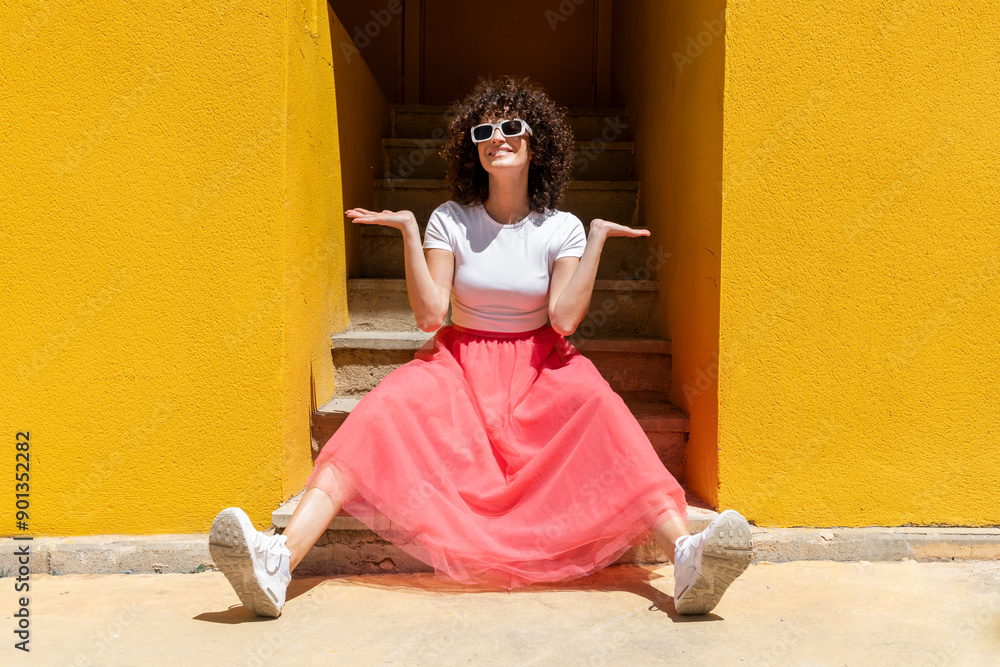 © VISTA by Westend61 - Smiling woman sitting on steps near yellow wall © VISTA by Westend61 - Smiling woman sitting on steps near yellow wall