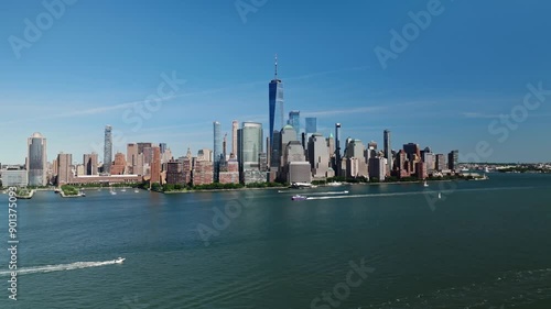 Aerial pullback reveals One World Trade Center along Hudson River as boats drive along waterway