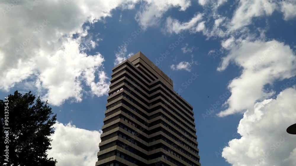 Urban Time-lapse, High-Rise Office Building Against White Clouds in Blue Sky, Low Angle View Urban Time-lapse, High-Rise Office Building Against White Clouds in Blue Sky, Low Angle View