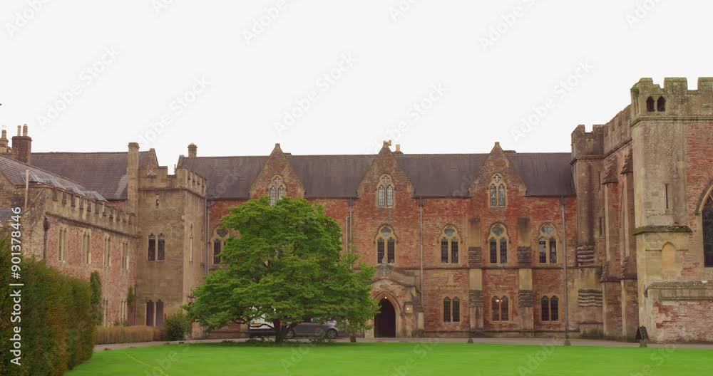 View of old medieval architecture of Bishop's Palace with Chapel and green Croquet Lawn in Wells, England during daytime. 4k. View of old medieval architecture of Bishop's Palace with Chapel and green Croquet Lawn in Wells, England during daytime. 4k.