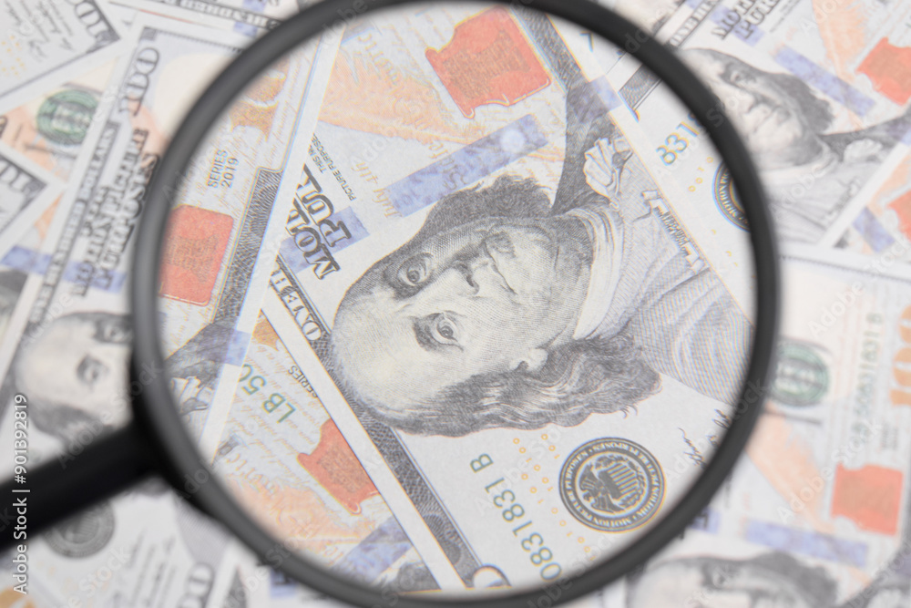 Closeup on magnifier glass with Benjamin Franklin on US dollar banknote. Texture US dollars. Banknotes. American money Closeup on magnifier glass with Benjamin Franklin on US dollar banknote. Texture US dollars. Banknotes. American money