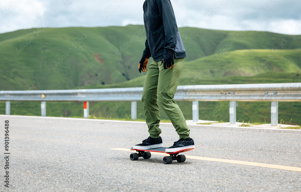 Skateboarder skateboarding on the mountain road Skateboarder skateboarding on the mountain road