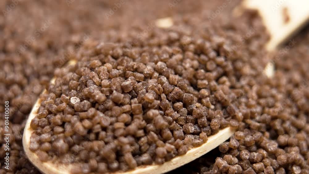 Organic gluten free buckwheat couscous grains falling on a bamboo spoon. Ecological vegan product. Macro shot Organic gluten free buckwheat couscous grains falling on a bamboo spoon. Ecological vegan product. Macro shot