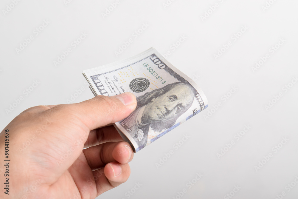 Man hand giving roll 100 dollar bills isolated on white background. One hundred dollar bills. Banknotes. $100 bills Man hand giving roll 100 dollar bills isolated on white background. One hundred dollar bills. Banknotes. $100 bills