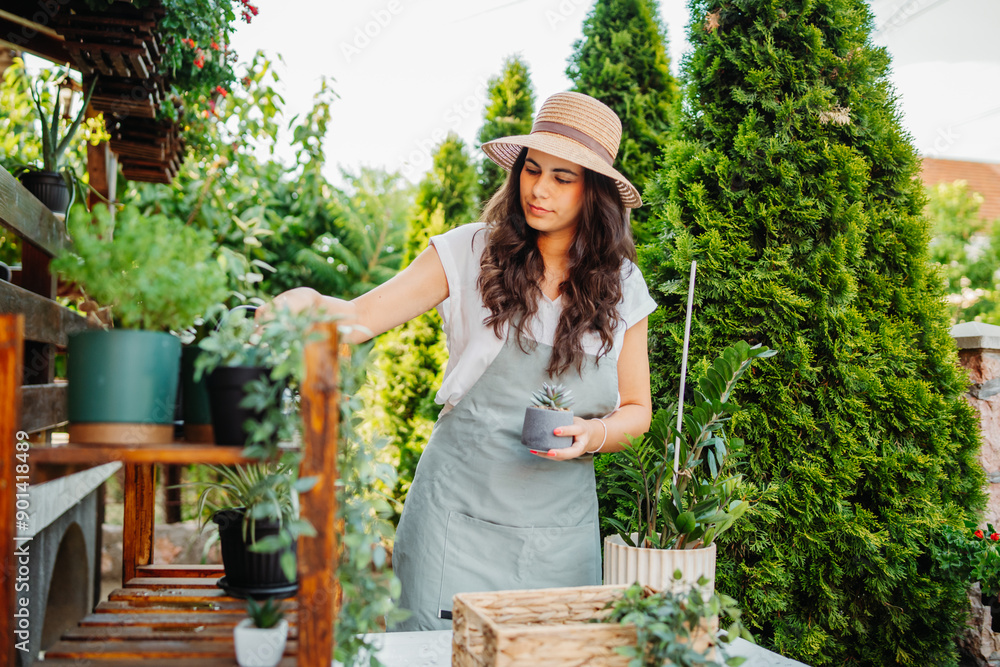 Obraz premium Young woman taking care of plants with water can and mister