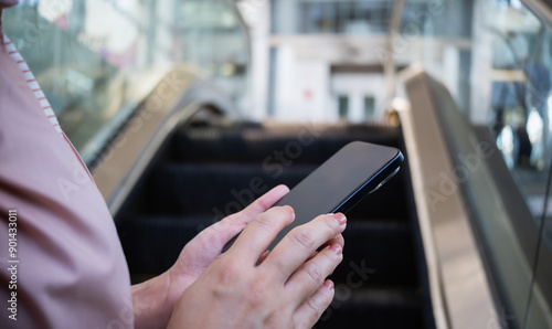 Woman use of smartphone in escalators in shopping malls.