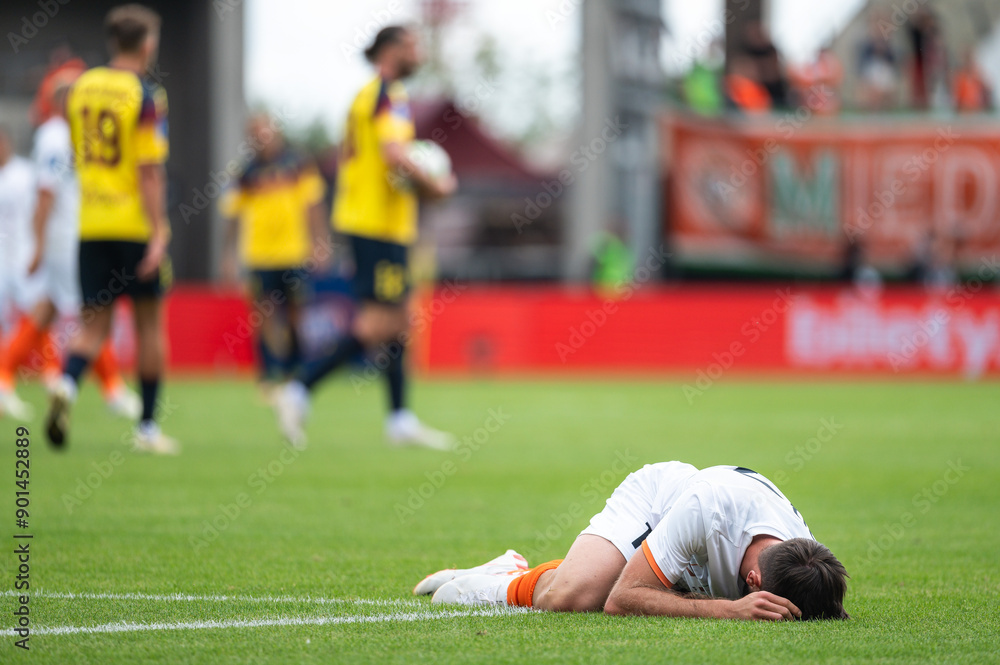 The injured footballer lies on the pitch.