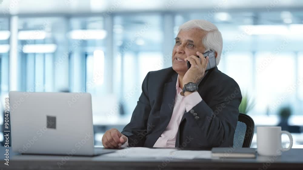 Happy Indian senior manager talking on mobile phone Happy Indian senior manager talking on mobile phone