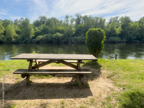 empty wooden picnic table in the park by river