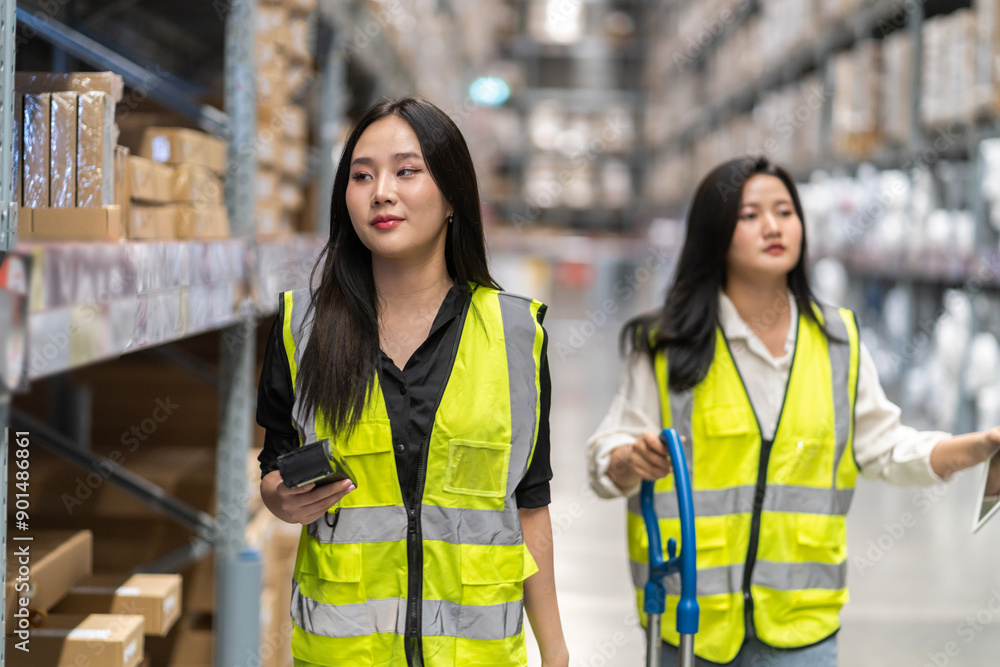 Asian two engineer team shipping order detail on tablet check goods and supplies on shelves with goods background inventory in factory warehouse.logistic industry and business export. Asian two engineer team shipping order detail on tablet check goods and supplies on shelves with goods background inventory in factory warehouse.logistic industry and business export.