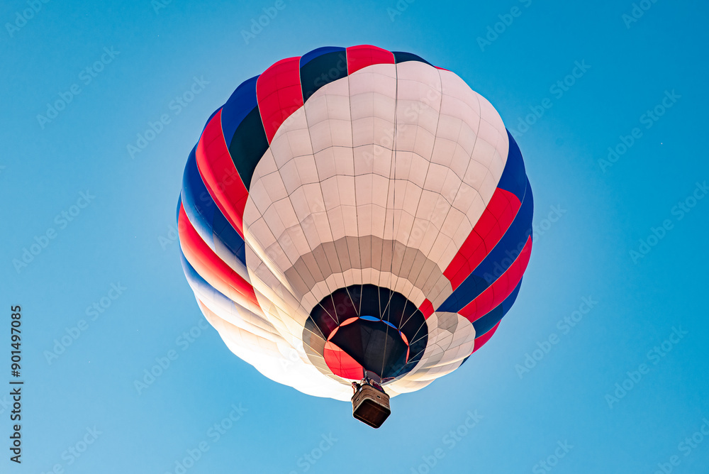 Obraz premium A colorful hot air balloon floating across the blue sky