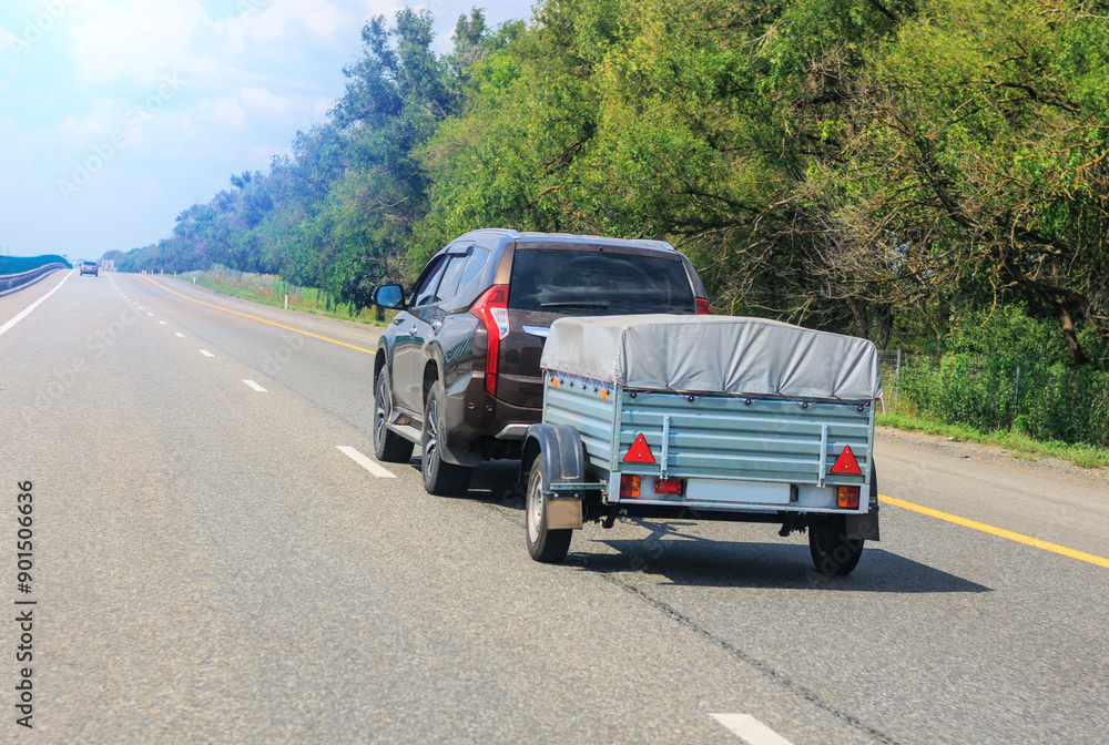 SUV with a trailer moves along a road SUV with a trailer moves along a road